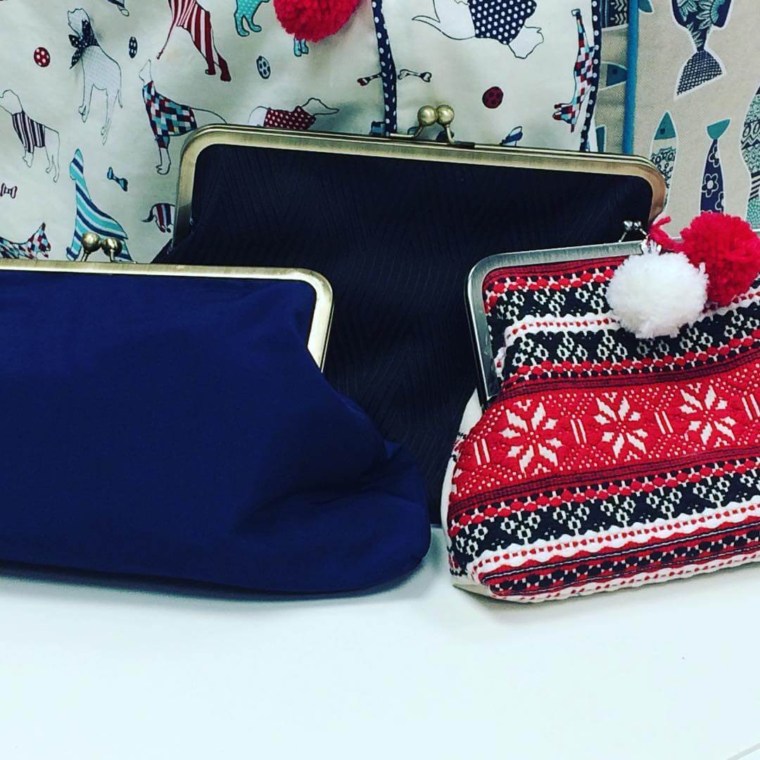 Three clutch bags in blue, red and black.